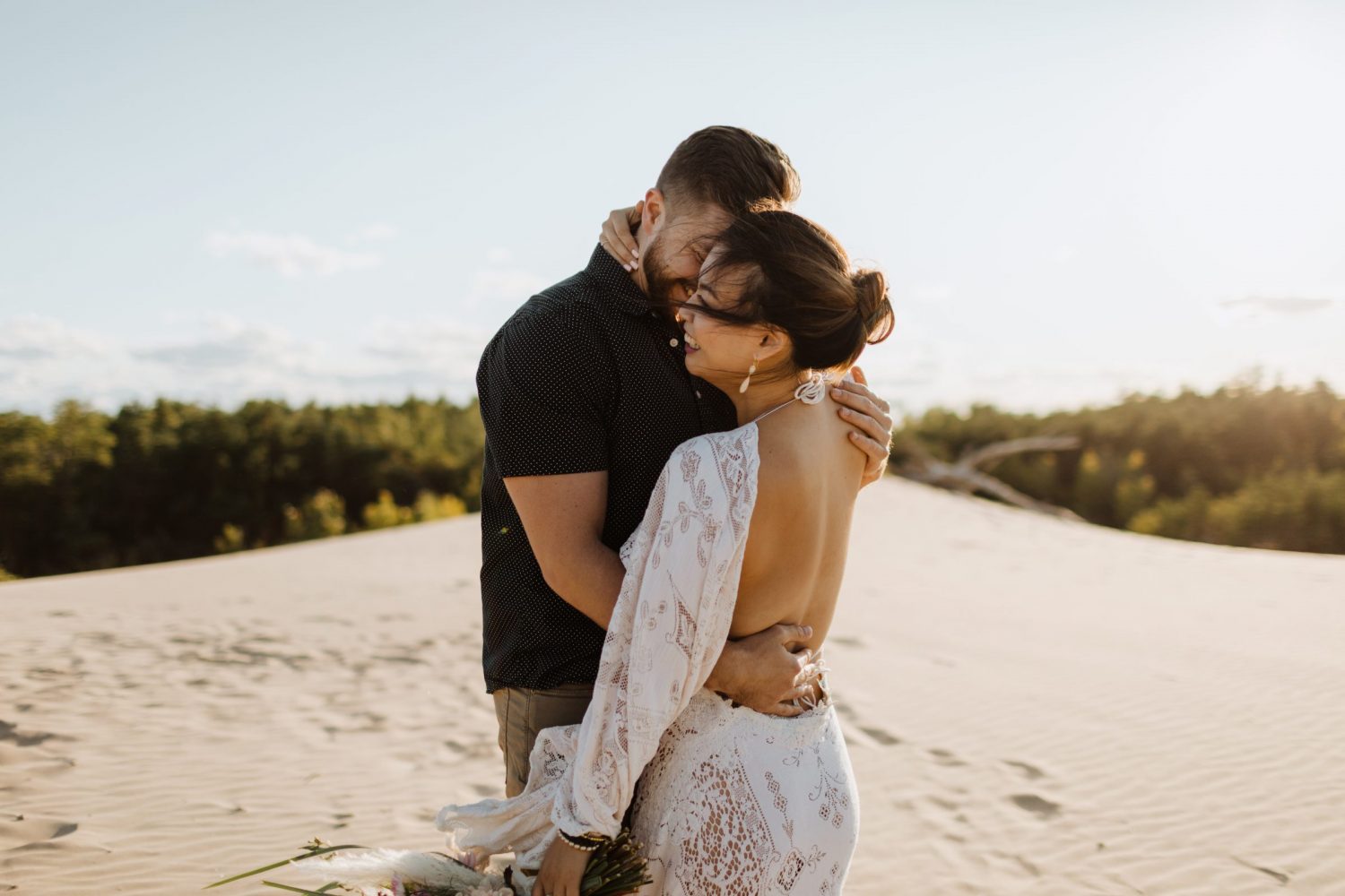 bride and groom hugging on a sandbanks