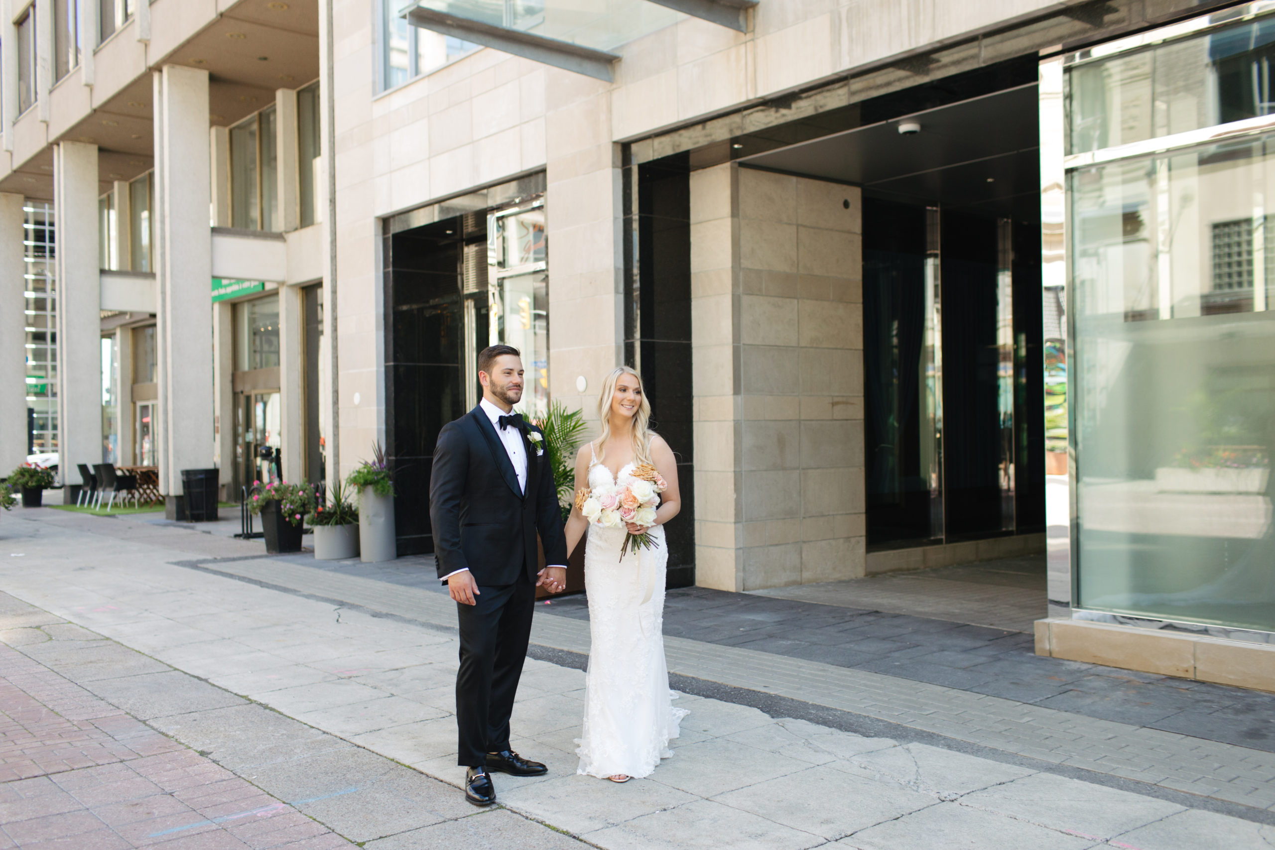 Ottawa Lago Wedding Couple dress in wedding attire standing in front of a building